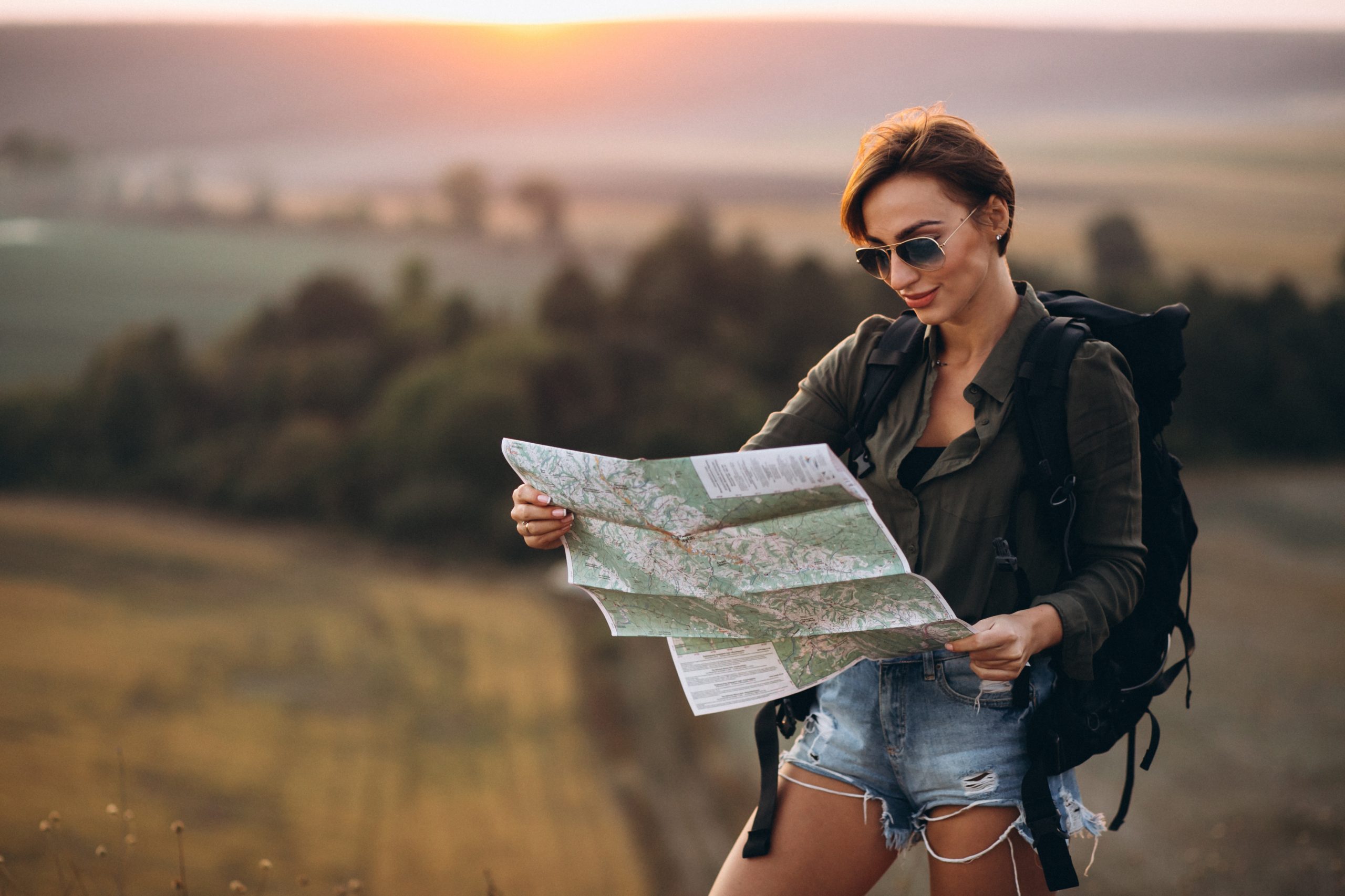 woman-hiking-mountains-looking-map-scaled.jpg