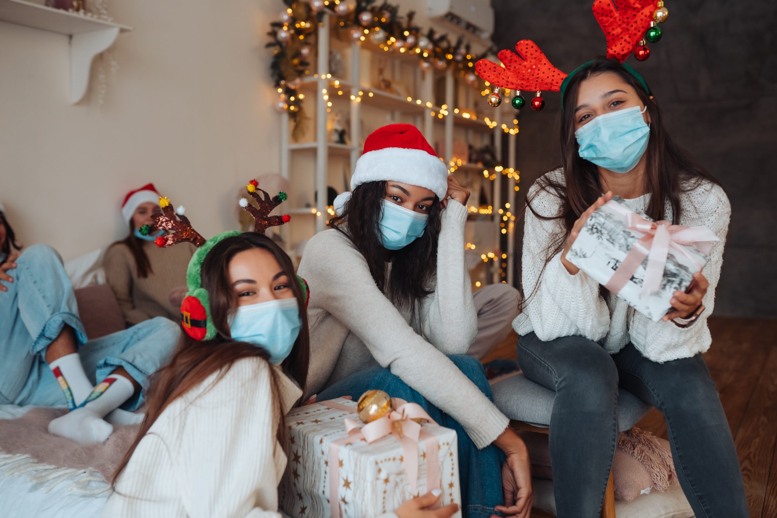 multiethnic-group-friends-santa-hats-smiling-posing-camera-with-gifts-hands-concept-celebrating-new-year-christmas-coronavirus-restrictions-holiday-quarantine-scaled.jpg